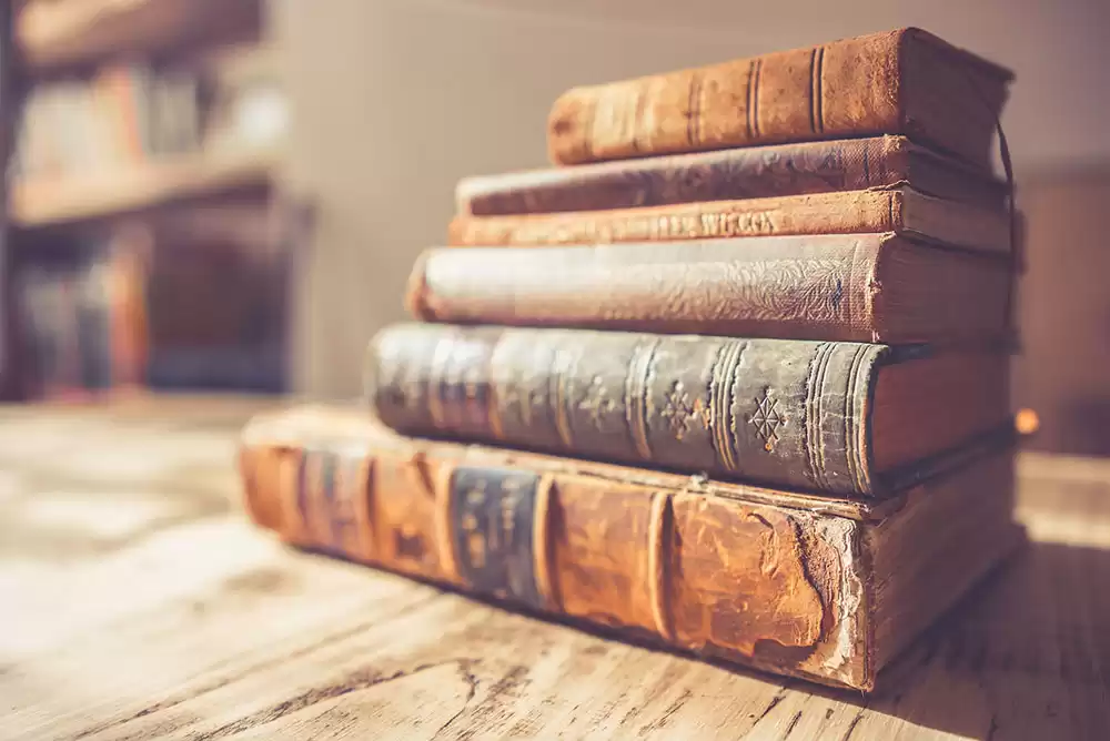 Six valuable first edition books stacked on a counter